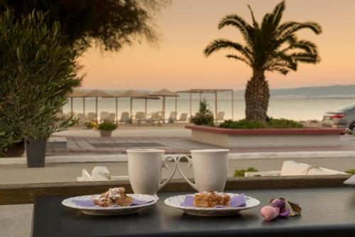 due tazze di caffè seduti su un tavolo con cibo di Hotel Pithari a Agia Triada