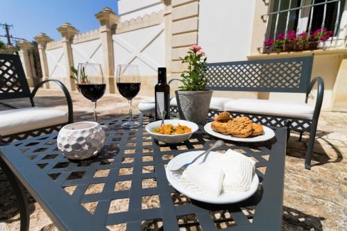 un tavolo con bicchieri di vino e cibo sopra di Casina Bardoscia a Cutrofiano