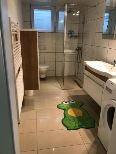 uma casa de banho com um tapete de rã verde no chão em Apartment em Reutlingen