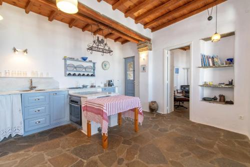 a kitchen with blue cabinets and a table at Sylvia House in Arnados