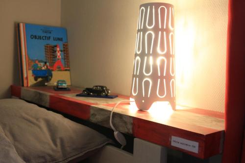 a table with a lamp on top of a bed at Les Hauts de Crupet in Maillen