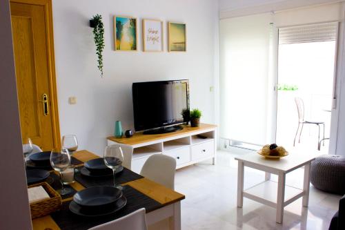 salon ze stołem i telewizorem w obiekcie Seaview Fuengirola Apartment by JITKey w mieście Fuengirola