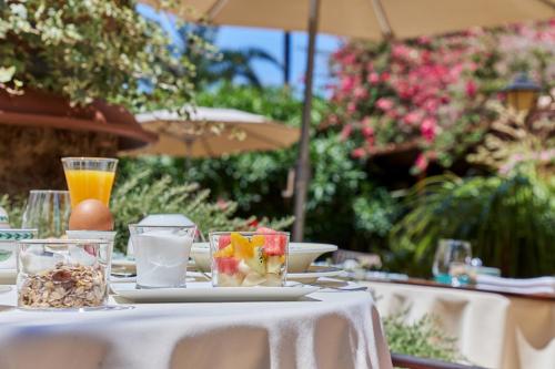 una mesa con un plato de comida y bebidas. en Petit Hotel Ses Rotges - Only Adults, en Cala Ratjada