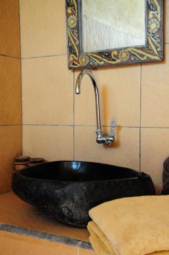 a black sink with a faucet in a bathroom at Gili Flush Harmony in Gili Trawangan