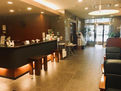 a kitchen area with a table and chairs at Hotel Route-Inn Fukaya Ekimae in Fukaya