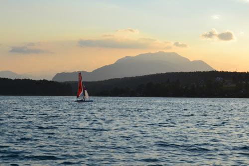 a sailboat on a lake with mountains in the background at Theresienhof in Petschnitzen