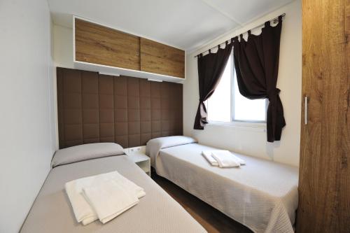 una camera con due letti e una finestra di Camping Bella Italia a Peschiera del Garda
