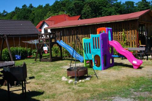 einen Spielplatz mit Rutsche und Spielset in der Unterkunft Domki Letniskowe "Przy Parku" in Wisełka