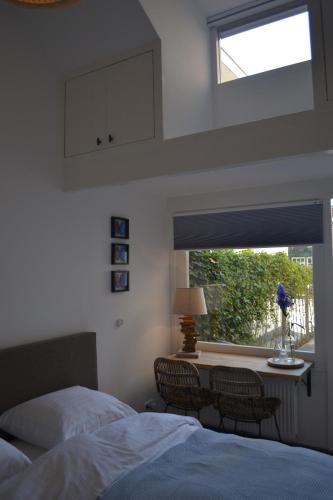 a bedroom with two beds and a window at Behind the Beach in Zandvoort