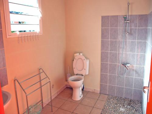 uma casa de banho com um WC e um chuveiro em GITE-Hotel LA CAZ DES ORANGERS em Le Bois de Nèfles