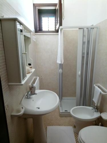 uma casa de banho com um lavatório, um chuveiro e um WC. em Apartment of kite and wine em Birgi Vecchi