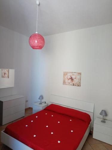 a bedroom with a red bed with a red blanket at Apartment of kite and wine in Birgi Vecchi