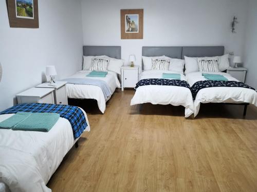 three beds in a room with wooden floors at Varanski Vista in San Miguel de Abona