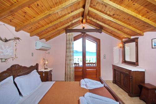 sypialnia z łóżkiem i dużym oknem w obiekcie Pelagos Villas w mieście Agios Dimitrios