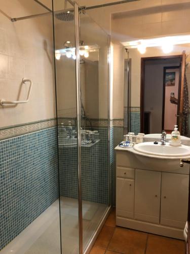 a bathroom with a glass shower and a sink at Caravela A in Lagos