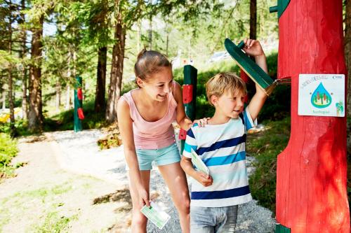a boy and a girl standing next to a pole at Hotel Enzian in Pertisau