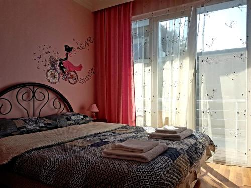 a bedroom with a bed with towels on it at Calypso Kvariati Hotel in Kvariati