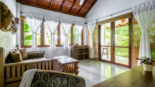 a living room with windows and a couch and a table at Good Karma in Tangalle