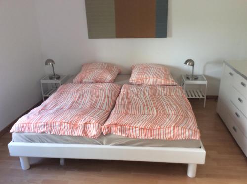 un letto con due cuscini sopra in una camera da letto di Altstadt Bonn mit eigenem Parkplatz und Garten a Bonn