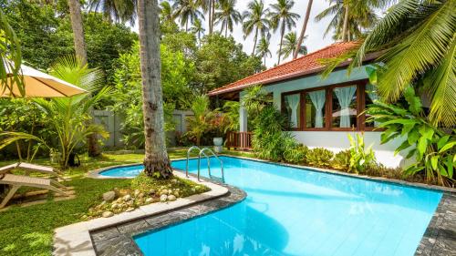 a villa with a swimming pool and a house at Good Karma in Tangalle