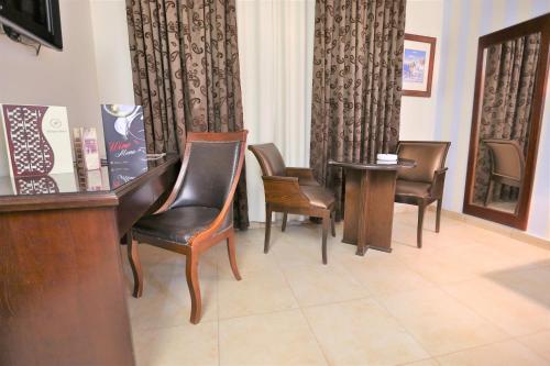 a waiting room with chairs and a table and a hair salon at Hisham Hotel in Amman