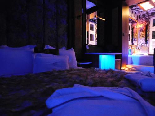 a dark room with a bed with white pillows at Mała Anglia Deluxe Rooms & SPA in Sopot