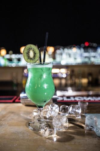 a green drink with a kiwi on a table at Hisham Hotel in Amman