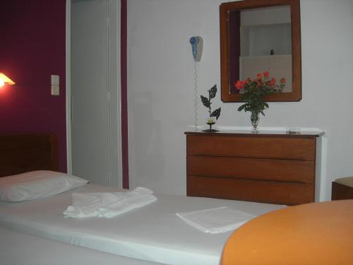 a bedroom with a bed with a dresser and a mirror at Chrysa House in Kamarai