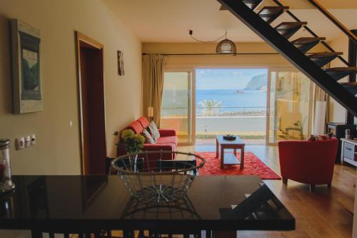 a living room with a view of the ocean at Sunrise House in Ponta Delgada