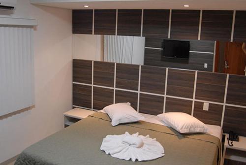 ein Schlafzimmer mit einem Bett mit zwei Handtüchern darauf in der Unterkunft Catu Palace Hotel in Rondonópolis