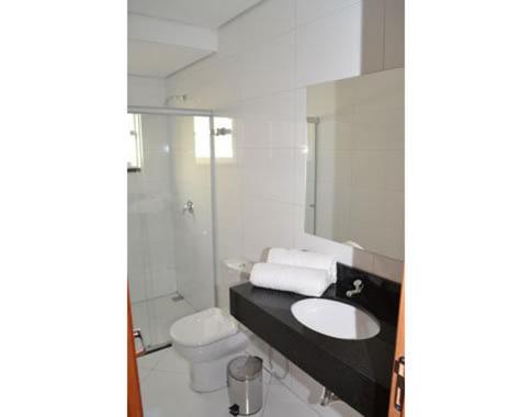 uma casa de banho com um lavatório, um WC e um espelho. em Catu Palace Hotel em Rondonópolis