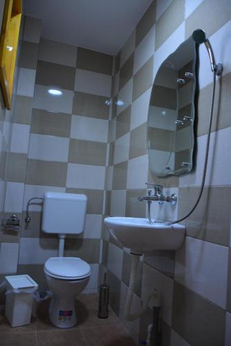 a bathroom with a toilet and a sink and a mirror at Casa Moața La Vama Veche in Vama Veche