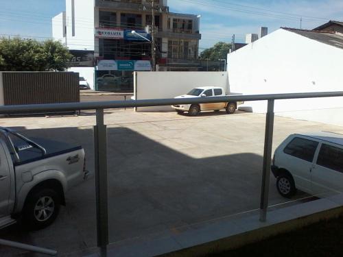 a car parked in a parking lot with a truck at Catu Palace Hotel in Rondonópolis
