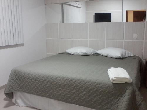 a bedroom with a bed with two pillows on it at Catu Palace Hotel in Rondonópolis