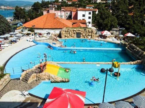 a large swimming pool in a resort with people in it at Apartmaji Zonta in Koper
