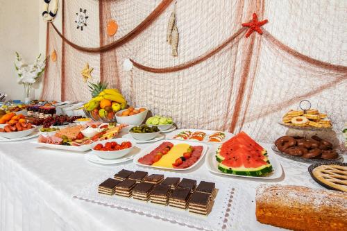 a table with many different types of food on it at Skalinada Sea View in Lokva Rogoznica