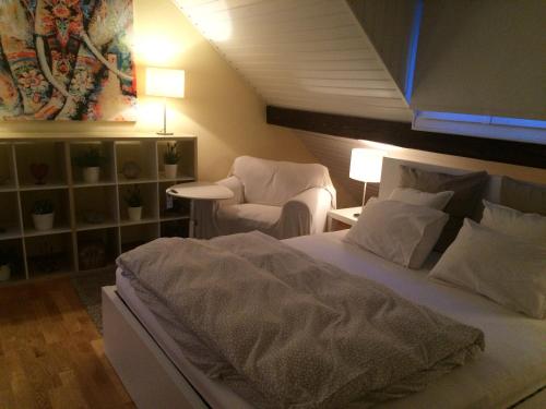 a bedroom with a large bed and a chair at Cozy Attica - With Every Comfort - Berne in Liebefeld