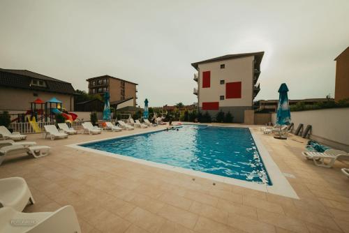 a large swimming pool with lounge chairs and a playground at Sangria Luxury Family in Mamaia Nord