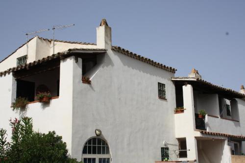 a white building with potted plants on the windows at Casa Vacanze Paola 2 in Santa Luria