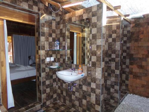 un baño con lavabo y espejo en Green Bowl Beach Villas, en Uluwatu