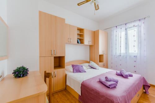 a bedroom with two purple pillows on a bed at Holiday house Barbara in Supetar