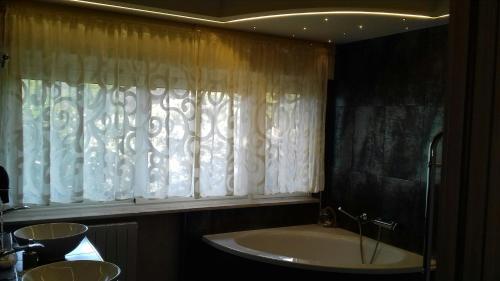 a bathroom with a bath tub and a window at Blumarine Dh in Formia