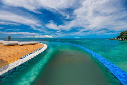 a swimming pool on the side of a boat in the water at Coco de Mer Hotel and Black Parrot Suites in Grand'Anse Praslin