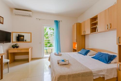 a bedroom with a bed and a desk and a television at Holiday house Barbara in Supetar