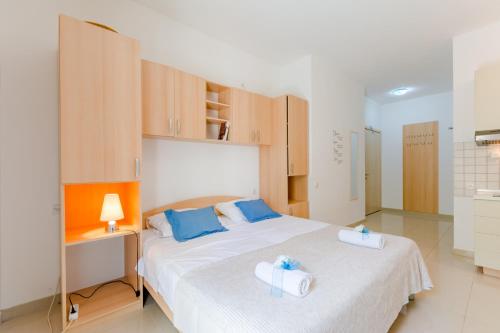 a bedroom with a large white bed with blue pillows at Holiday house Barbara in Supetar