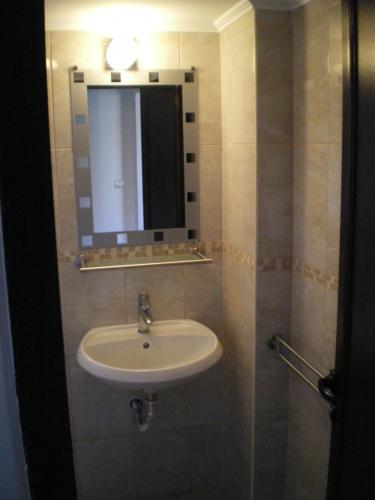 a bathroom with a sink and a mirror at Park View Apartment Plovdiv with Parking in Plovdiv