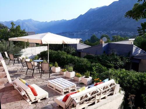 a patio with a table and chairs and an umbrella at Maritimo Apartments in Kotor