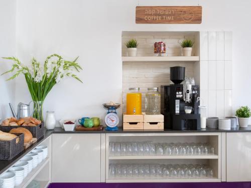 a kitchen with a shelf filled with water glasses at Metulla Travel Hotel in Metulla