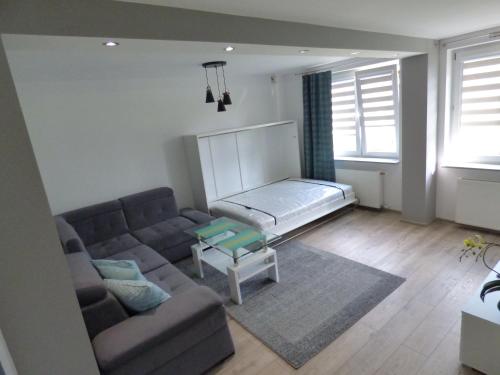 ein Wohnzimmer mit einem Sofa und einem Tisch in der Unterkunft Apartament Blekit Nieba in Tykocin