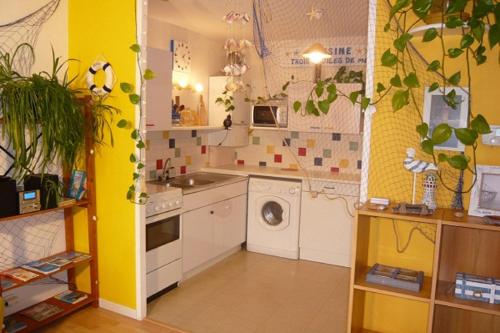 uma cozinha com um lavatório e uma máquina de lavar roupa em Les Comptoirs em Saint Malo